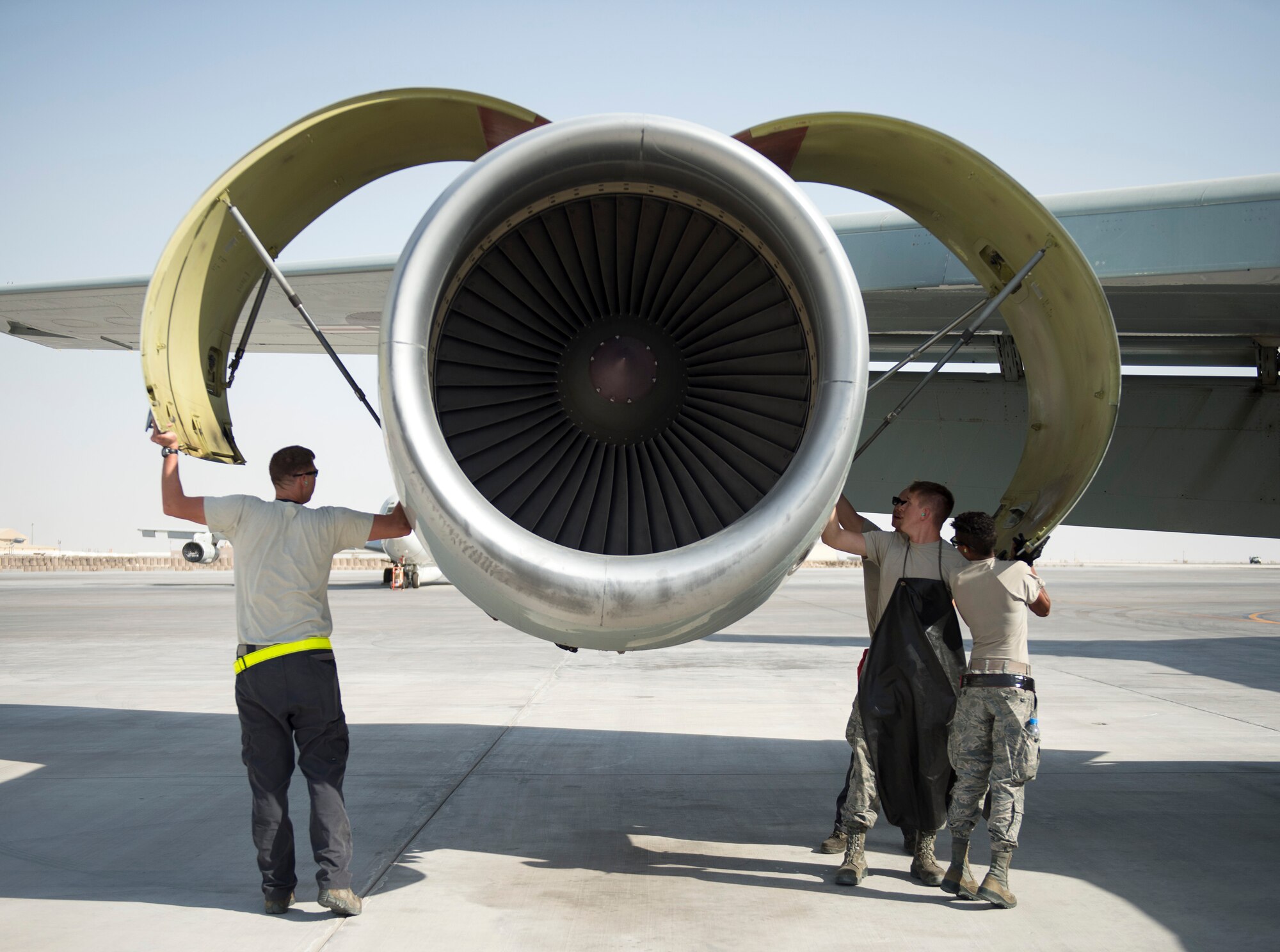 U.S Air Force Airmen with the 763rd Expeditionary Aircraft Maintenance Unit, open  the access panels to a RC-135V/W Rivet Joint engine at Al Udeid Air Base, Qatar, July 27, 2017.