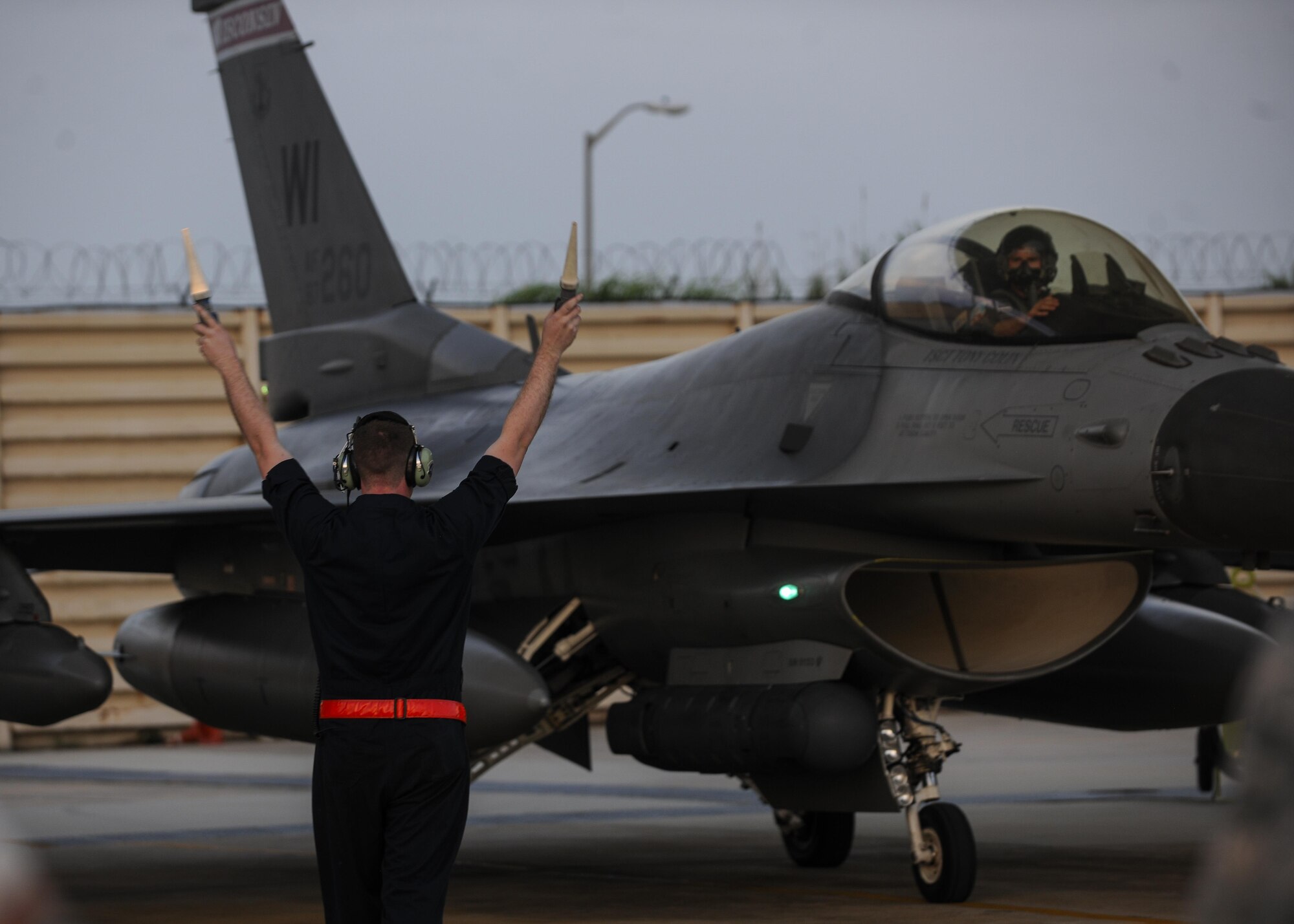 A U.S. Air Force Airman marshals an F-16 Fighting Falcon, or more commonly a Viper, assigned to the 176th Fighter Squadron, 115th Fighter Wing, Wisconsin Air National Guard into a spot at Kunsan Air Base, Republic of Korea, Aug. 3, 2017.