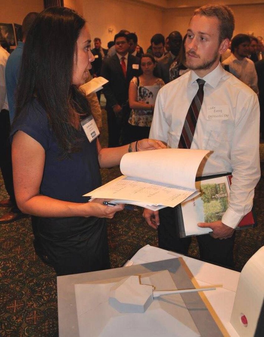 Image: Camille Ward - Laser and Optic Systems Branch head at the Naval Surface Warfare Center Dahlgren Division (NSWCDD) - discusses career opportunities with a candidate at an NSWCDD job fair.
