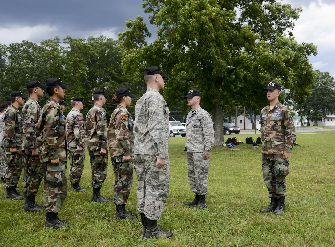 Air Force Airmen 1st Class Shawn and Kevin Utermohlen inspect a Civil Air Patrol cadet formation.
