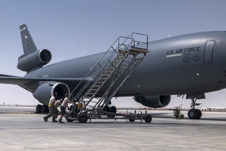 380th Aircraft Maintenance Squadron Extender Aircraft Maintenance Unit Airmen push a set of air stairs into position to offload aircraft crew August 3, 2017, at Al Dhafra Air Base, United Arab Emirates.