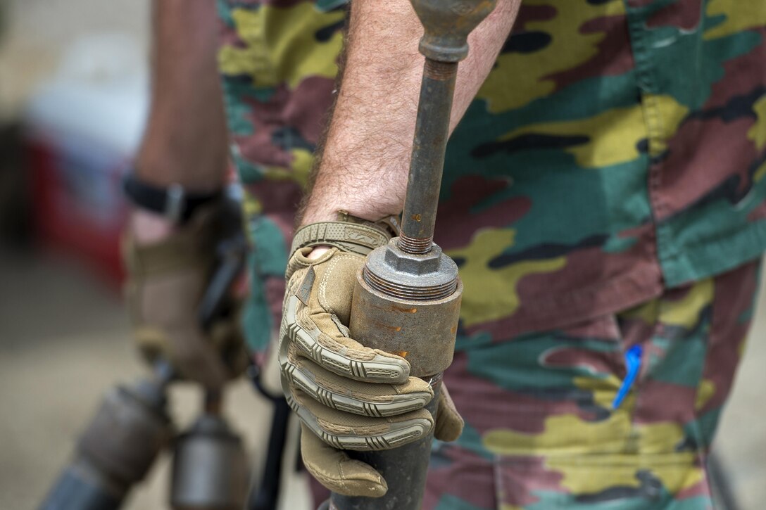 A soldier carries an explosive.