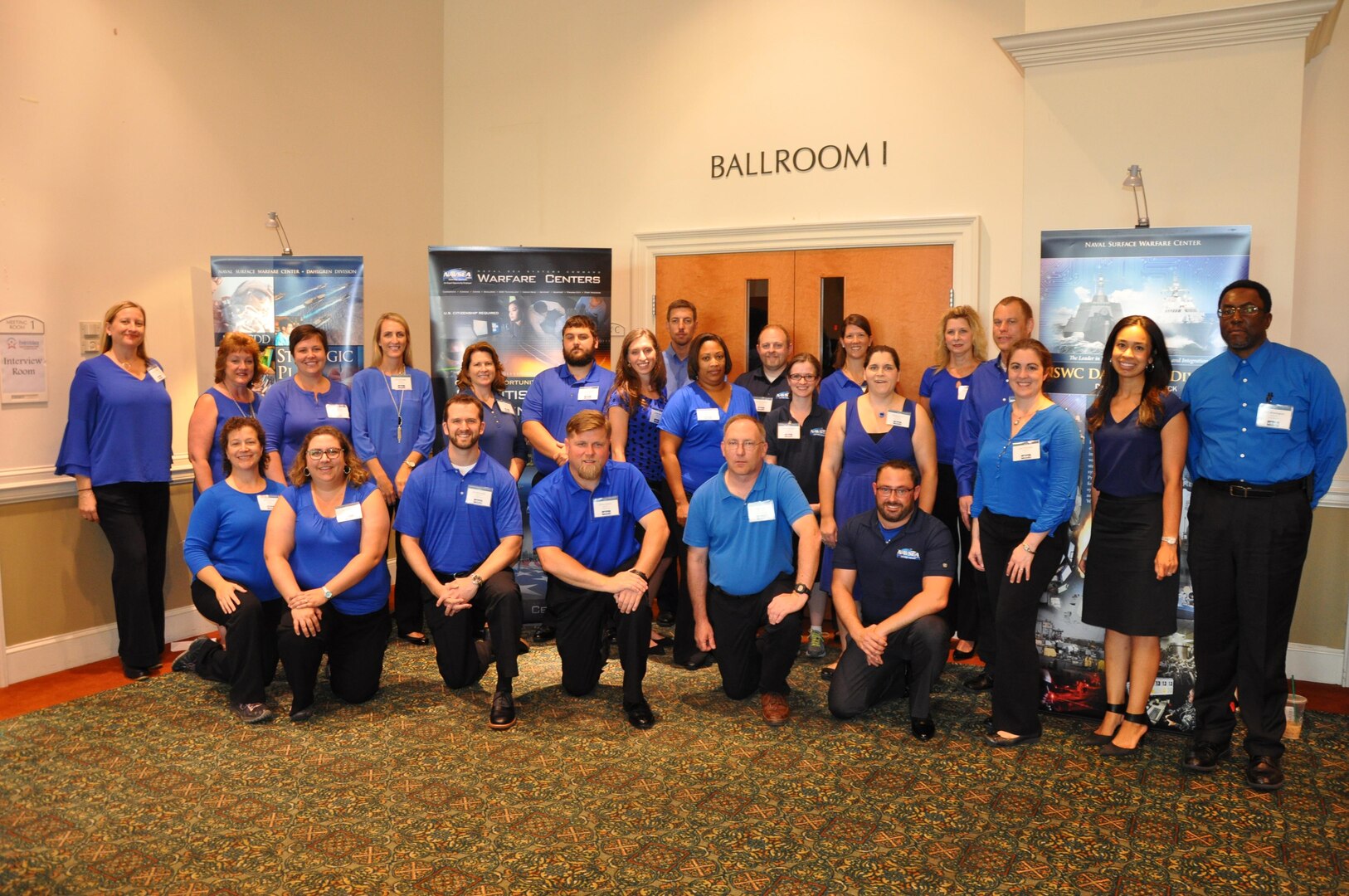 Employees of the Naval Surface Warfare Center Dahlgren Division (NSWCDD) pose for a photo before the start of a job fair held at the Fredericksburg Expo and Conference Center, July 18. The command's Human Resources Division announced Aug. 2 that it plans to make about 100 tentative job offers to candidates who attended the event. Approximately 325 candidates with bachelor's, master's, and doctoral degrees in biology, chemistry, computer science, engineering, mathematics, and physics spoke with senior Navy scientists, engineers, and managers about positions available for entry-level and experienced scientists and engineers.