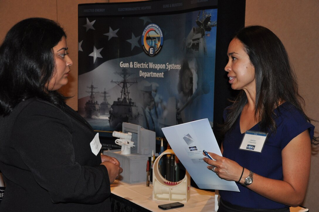 Image: Camille Ward - Laser and Optic Systems Branch head at the Naval Surface Warfare Center Dahlgren Division (NSWCDD) - discusses career opportunities with a candidate at an NSWCDD job fair. The command's Human Resources Division announced Aug. 2 that it plans to make about 100 tentative job offers to candidates who attended the event. Approximately 325 candidates with bachelor's, master's, and doctoral degrees in biology, chemistry, computer science, engineering, mathematics, and physics spoke with senior Navy scientists, engineers, and managers about positions available for entry-level and experienced scientists and engineers.