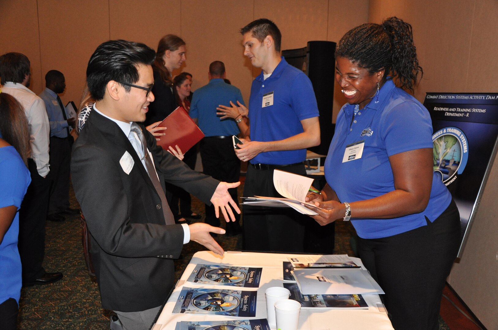 Tiffany Owens - employee of the Readiness & Training Systems Department at the Naval Surface Warfare Center Dahlgren Division (NSWCDD) - discusses career opportunities with a candidate at an NSWCDD job fair. The command's Human Resources Division announced Aug. 2 that it plans to make about 100 tentative job offers to candidates who attended the event. Approximately 325 candidates with bachelor's, master's, and doctoral degrees in biology, chemistry, computer science, engineering, mathematics, and physics spoke with senior Navy scientists, engineers, and managers about positions available for entry-level and experienced scientists and engineers.