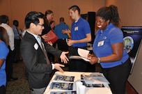 Tiffany Owens - employee of the Readiness & Training Systems Department at the Naval Surface Warfare Center Dahlgren Division (NSWCDD) - discusses career opportunities with a candidate at an NSWCDD job fair. The command's Human Resources Division announced Aug. 2 that it plans to make about 100 tentative job offers to candidates who attended the event. Approximately 325 candidates with bachelor's, master's, and doctoral degrees in biology, chemistry, computer science, engineering, mathematics, and physics spoke with senior Navy scientists, engineers, and managers about positions available for entry-level and experienced scientists and engineers.