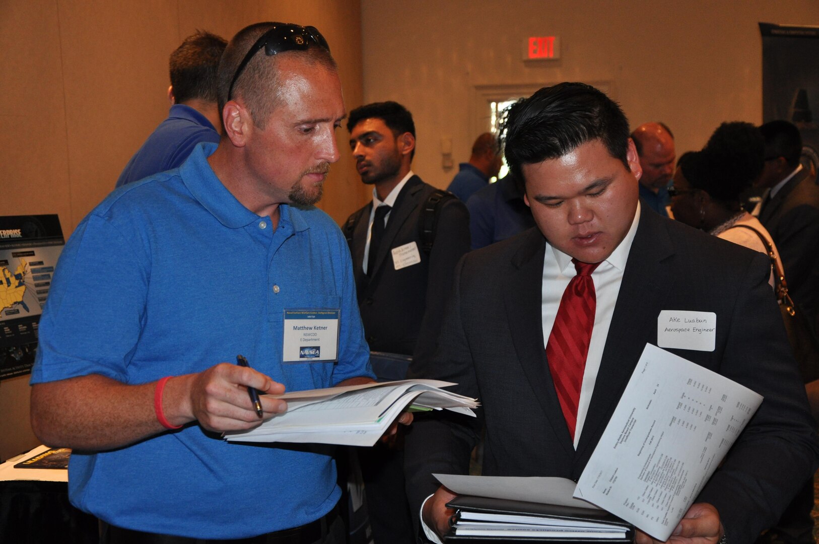 Image: Matthew Ketner - and employee of the Gun and Electric Systems Department at the Naval Surface Warfare Center Dahlgren Division (NSWCDD) - discusses career opportunities with a candidate at an NSWCDD job fair. The command's Human Resources Division announced Aug. 2 that it plans to make about 100 tentative job offers to candidates who attended the event. Approximately 325 candidates with bachelor's, master's, and doctoral degrees in biology, chemistry, computer science, engineering, mathematics, and physics spoke with senior Navy scientists, engineers, and managers about positions available for entry-level and experienced scientists and engineers.