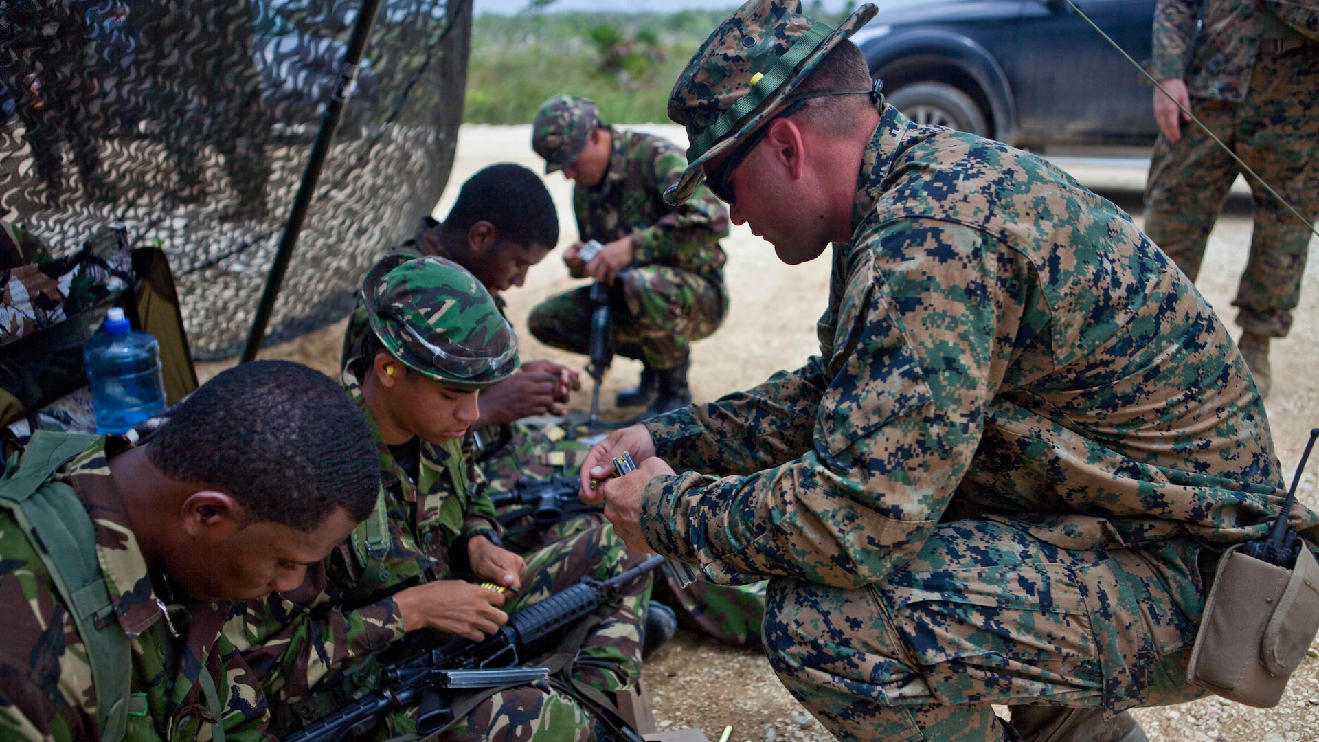 U.S. Marine Sgt. Dustin J. Houghton, an infantry trainer with the Belize Detachment, Ground Combat Element, Special Purpose Marine Air-Ground Task Force - Southern Command, shows service members with the Belize Defence Force how to load their ammunition into magazines as part of basic combat marksmanship training near Ladyville, Belize, July 20, 2017. The training was part of basic infantry skills course taught by the detachment to members of the BDF. The Marines and sailors of SPMAGTF-SC are deployed to Central America for the next six months to conduct security cooperation training and engineering projects with their counterparts in Honduras, Guatemala, Belize and El Salvador.