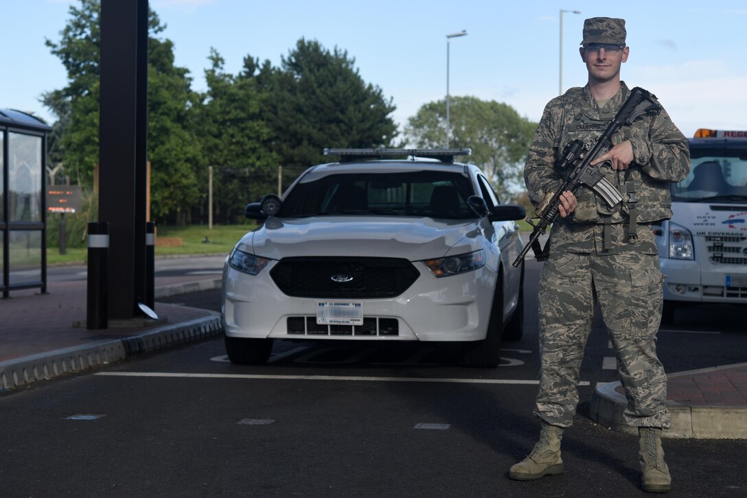 U.S. Air Force Airman 1st Class John A. Crawford, a 48th Fighter Wing photojournalist, observes traffic flow around a gate as part of Security Forces Augmentee duty at Royal Air Force Lakenheath, England, July 27. Security forces augmentee duty is used to temporarily assist security forces squadrons during deployment periods.(U.S. Air Force photo/Airman 1st Class Eli Chevalier)