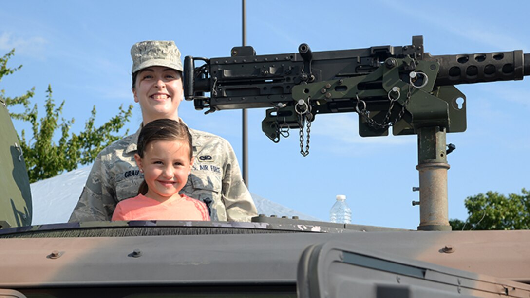 Air Force Senior Airman Kelly A. Grau, a member of the 177th Fighter Wing’s Security Forces Squadron, poses for a photo with a community member during Hamilton Township’s National Night Out at the Hamilton Mall in Mays Landing, New Jersey, on Aug. 1, 2017.