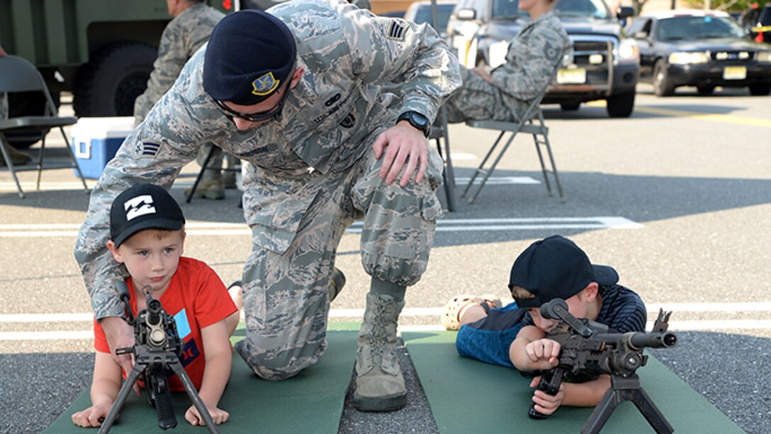 Air Force Senior Airman Zachary D. Ferguson, a member of the 177th Fighter Wing’s Security Forces Squadron, shows a community member how to use security forces equipment during Hamilton Township’s National Night Out at the Hamilton Mall in Mays Landing, New Jersey, on Aug. 1, 2017.