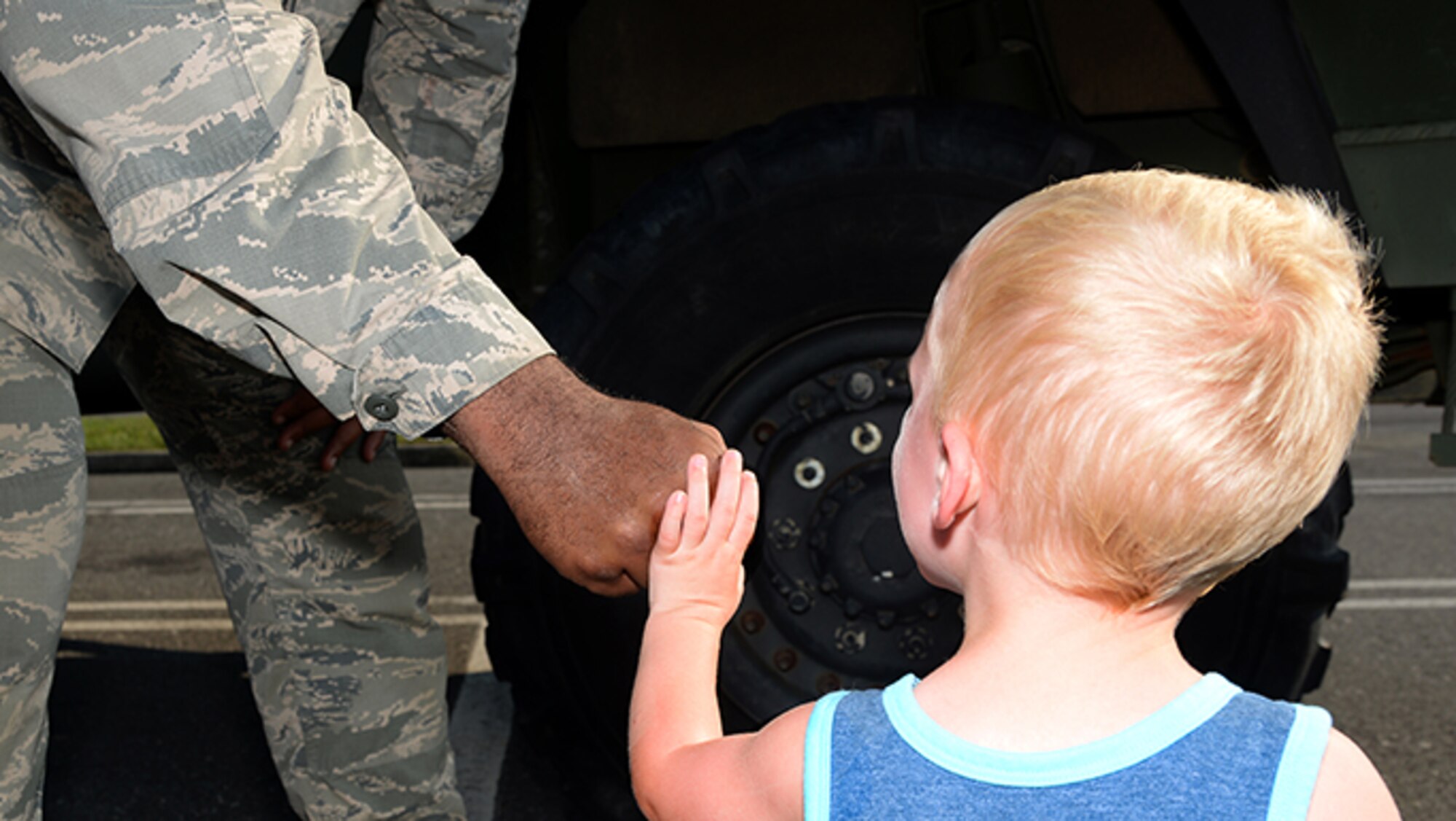 A picture of U.S. Air Force Staff Sgt. John D. Lundy, a member of the 177th Fighter Wing’s Security Forces Squadron, fist bumps with a community members.