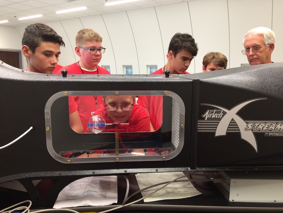 Students looking in wind tunnel.