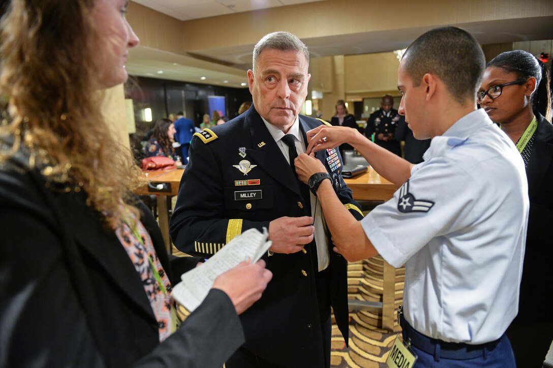 A videographer puts a microphone on Army Chief Staff Gen. Mark A. Milley.