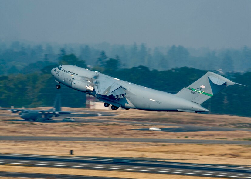 A C-17 Globemaster III flies into hazy skies, where smoke from the British Columbia, Canada wildfires blanket northwest Washington, Joint Base Lewis-McChord, Wash., Aug. 2,2017.  The smoke has resulted in a burn ban for the Tacoma area and has created visibility concerns for those participating in Mobility Guardian. More than 3,000 Airmen, Soldiers, Sailors, Marines and international partners converged on the state of Washington in support of Mobility Guardian. The exercise is intended to test the abilities of the Mobility Air Forces to execute rapid global mobility missions in dynamic, contested environments. Mobility Guardian is Air Mobility Command's premier exercise, providing an opportunity for the Mobility Air Forces to train with joint and international partners in airlift, air refueling, aeromedical evacuation and mobility support. The exercise is designed to sharpen Airmen’s skills in support of combatant commander requirements. (U.S. Air Force photo by Tech. Sgt. Jodi Martinez)