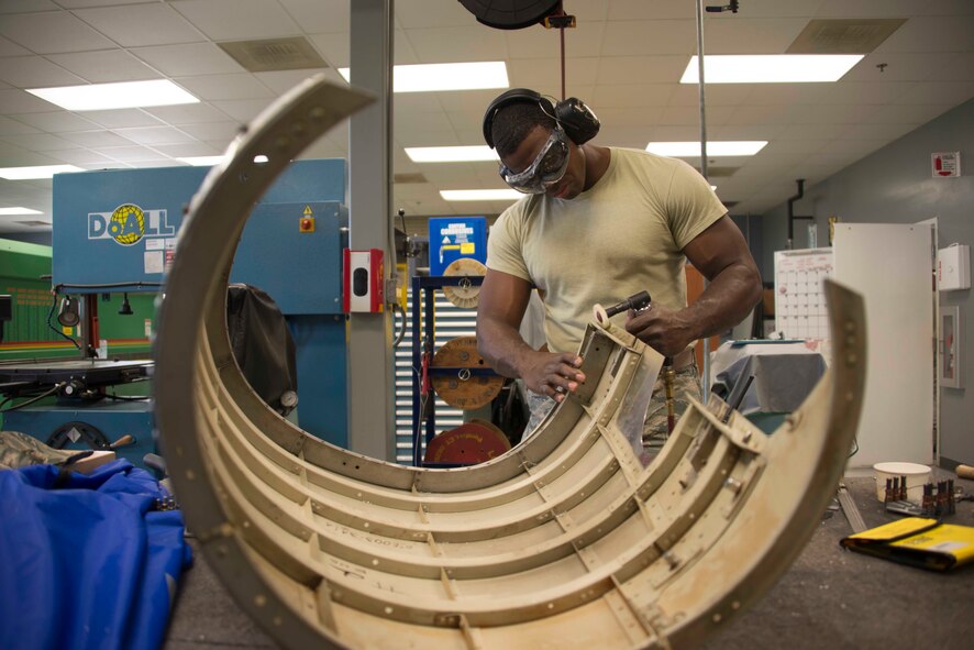 Senior Airman Marcellus Garner removes sealant while preparing a C-146A Wolfhound engine cowling