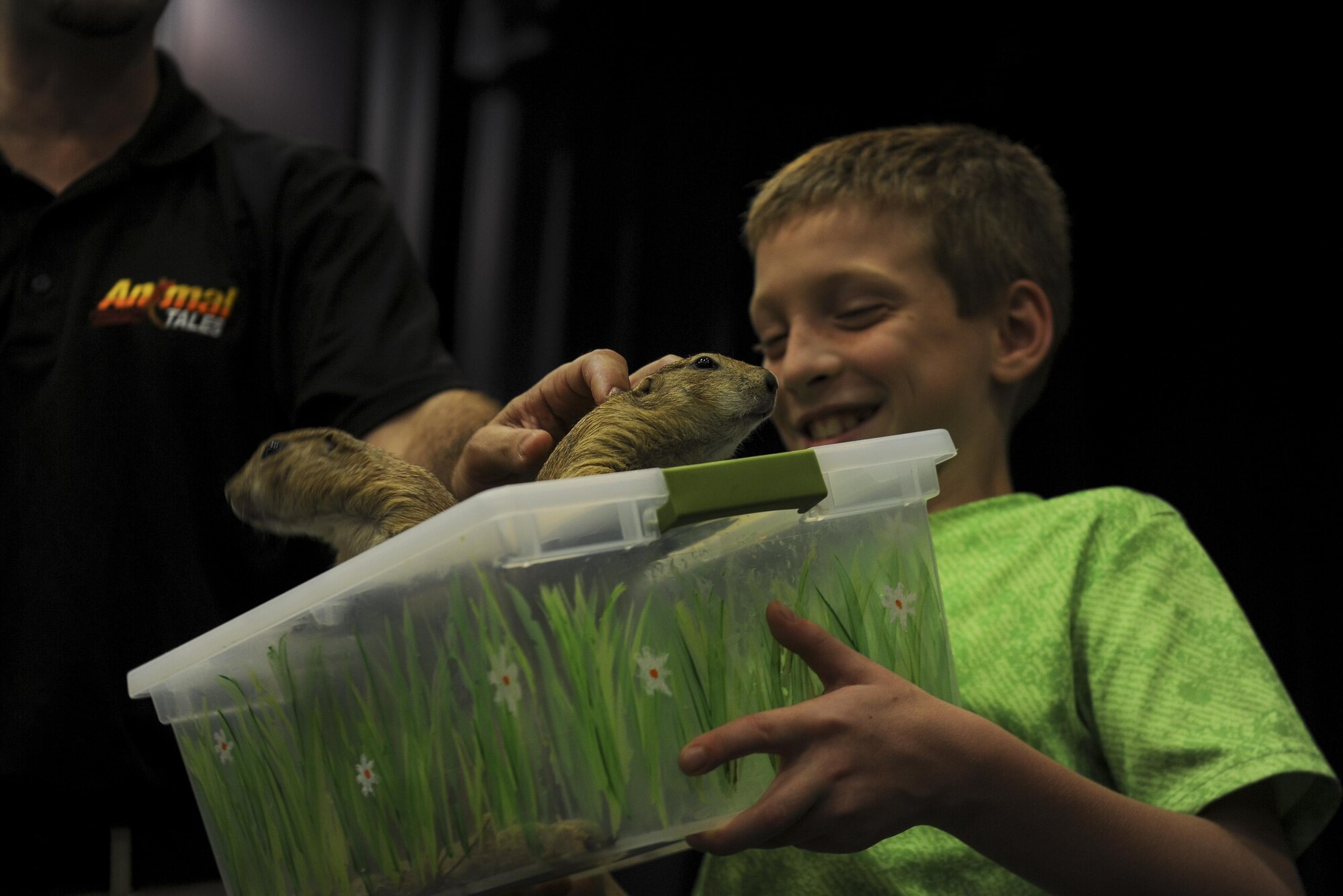 A kid holds two prairie dogs.