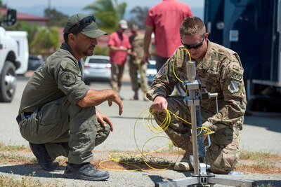 Air Force Staff Sgt. Brandon Ulmer, left, and Merl Mireles, an investigator with Orange County Sherriff's Department in California, prepare a controlled small blast firing device during the Raven's Challenge explosive ordnance disposal exercise at Camp Pendleton, Calif., Aug. 1, 2017. Raven's Challenge is an Army-funded exercise led by the Bureau of Alcohol, Tobacco, Firearms, and Explosives with support and participations from multiple federal, state and local agencies. DoD photo by EJ Hersom