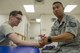 Technical Sgt. Harvey Tagudin, 374th Surgical Support Squadron physical therapist NCOIC, stretches the arm muscles of Staff Sgt. Matthew Tempest, 374th Aircraft Maintenance Squadron, aerospace propulsion craftsman, July 28, 2017 at Yokota Air Base, Japan. The stretching helps to increase blood flow in the muscles that have atrophied due to surgery or injury. (U.S. Air Force photo by Airman 1st Class Donald Hudson)