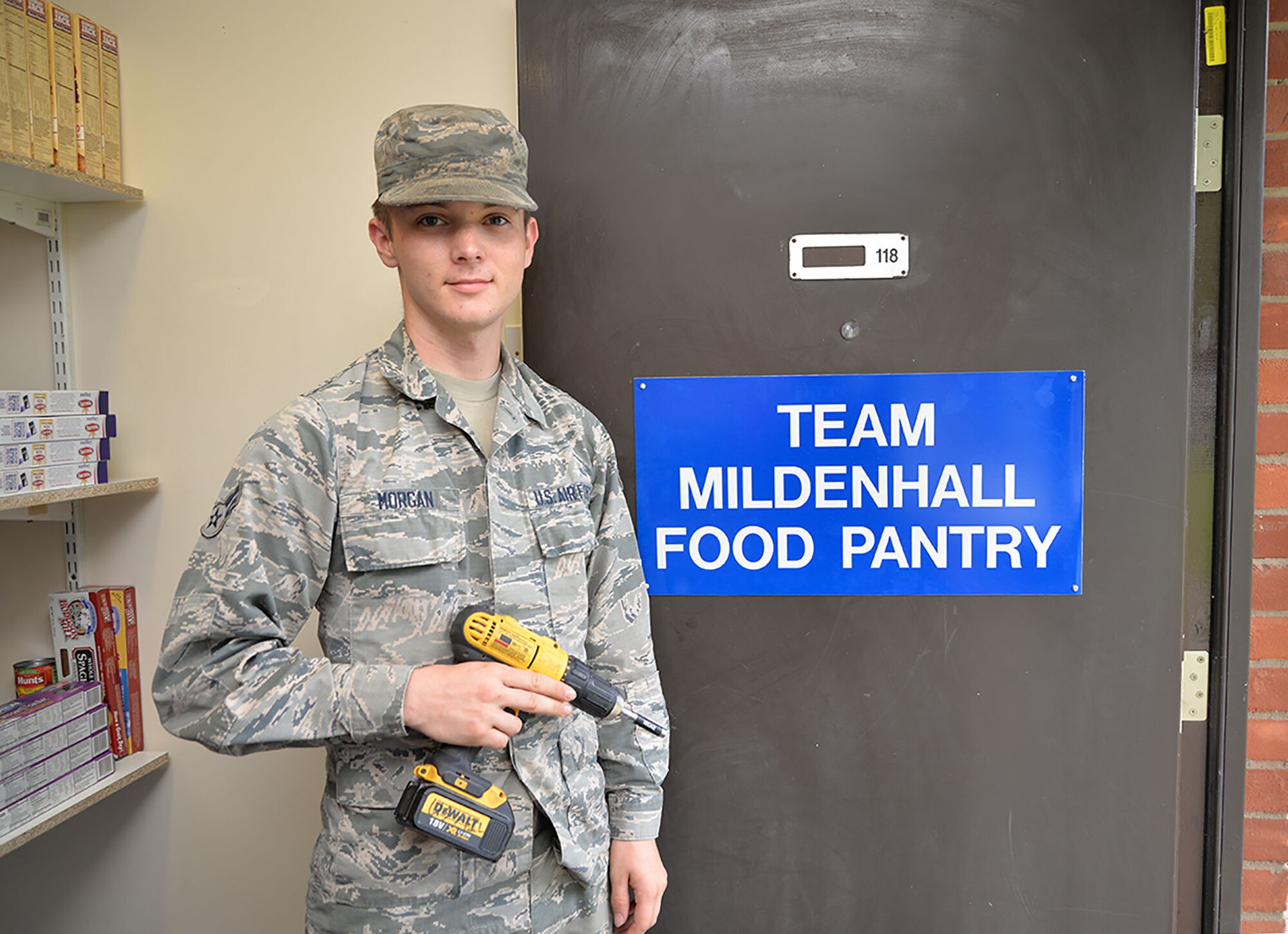U.S. Airman 1st Class Austin Morgan, 100th Civil Engineer Squadron Structures apprentice, finishes putting up a sign for the Team Mildenhall Food Pantry Aug. 3, 2017, ready for the grand opening on RAF Mildenhall, England. The 100th CES is one of many agencies, including first sergeants and key spouses, who have worked hard to get the food pantry up and running for Team Mildenhall Airmen and their dependents in need. (U.S. Air Force photo by Karen Abeyasekere