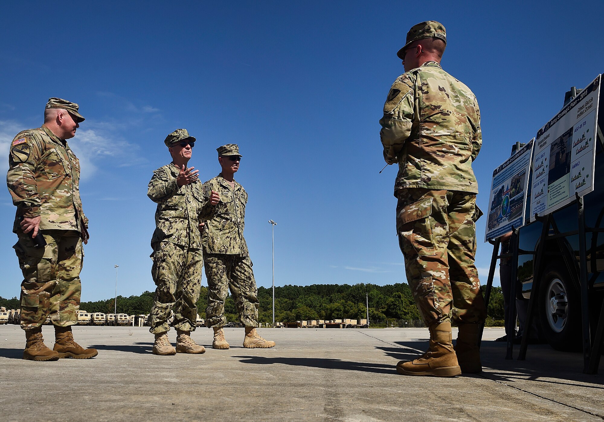 Lt. Col. Kenneth Hoisington, right, U.S. Army Logistics Activity Charleston director, briefs Rear Adm. Lawrence Jackson, center left, U.S. Transportation Command Strategy, Capabilities, Policy and Logistics Directorate outgoing director, Rear Adm. Peter Clarke, center right, USTRANSCOM Strategy, Capabilities, Policy and Logistics Directorate incoming director, and Lt. Col. Chad Blacketer, left, 841st Transportation Battalion commander, on operation details Aug. 1 during a tour of Wharf Alpha at the joint Base Charleston - Weapons Station as part of an orientation visit. Jackson and Clarke received a 437th Airlift Wing mission and 841st Transportation Battalion briefing, observed demonstrations and toured a C-17 Globemaster III and the 437th Aerial Port Squadron during the visit. USTRANSCOM is a unified, functional combatant command which provides support to the eight other U.S. combatant commands, the military services, defense agencies and other government organizations by providing full-spectrum global mobility solutions and related enabling capabilities for supported customers’ requirements in peace and war.