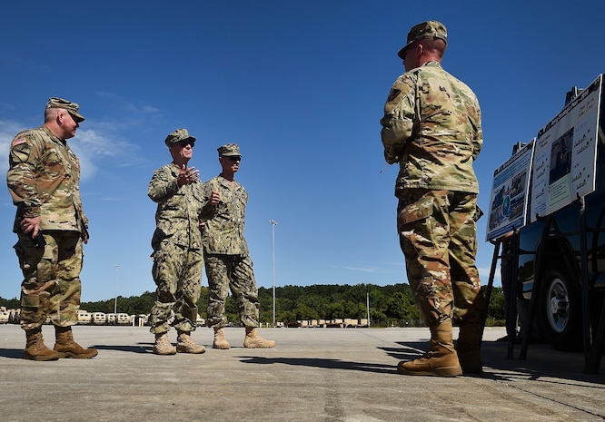 Lt. Col. Kenneth Hoisington, right, U.S. Army Logistics Activity Charleston director, briefs Rear Adm. Lawrence Jackson, center left, U.S. Transportation Command Strategy, Capabilities, Policy and Logistics Directorate outgoing director, Rear Adm. Peter Clarke, center right, USTRANSCOM Strategy, Capabilities, Policy and Logistics Directorate incoming director, and Lt. Col. Chad Blacketer, left, 841st Transportation Battalion commander, on operation details Aug. 1 during a tour of Wharf Alpha at the joint Base Charleston - Weapons Station as part of an orientation visit. Jackson and Clarke received a 437th Airlift Wing mission and 841st Transportation Battalion briefing, observed demonstrations and toured a C-17 Globemaster III and the 437th Aerial Port Squadron during the visit. USTRANSCOM is a unified, functional combatant command which provides support to the eight other U.S. combatant commands, the military services, defense agencies and other government organizations by providing full-spectrum global mobility solutions and related enabling capabilities for supported customers’ requirements in peace and war.