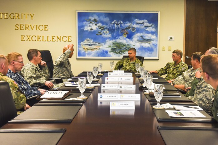 Joint Base Charleston leaders brief Rear Adm. Peter Clarke, center, U.S. Transportation Command Strategy, Capabilities, Policy and Logistics Directorate incoming director, and Rear Adm. Lawrence Jackson, Strategy, Capabilities, Policy and Logistics Directorate outgoing director, Aug. 1 during a JB Charleston mission brief here. USTRANSCOM is a unified, functional combatant command which provides support to the eight other U.S. combatant commands, the military services, defense agencies and other government organizations by providing full-spectrum global mobility solutions and related enabling capabilities for supported customers’ requirements in peace and war.