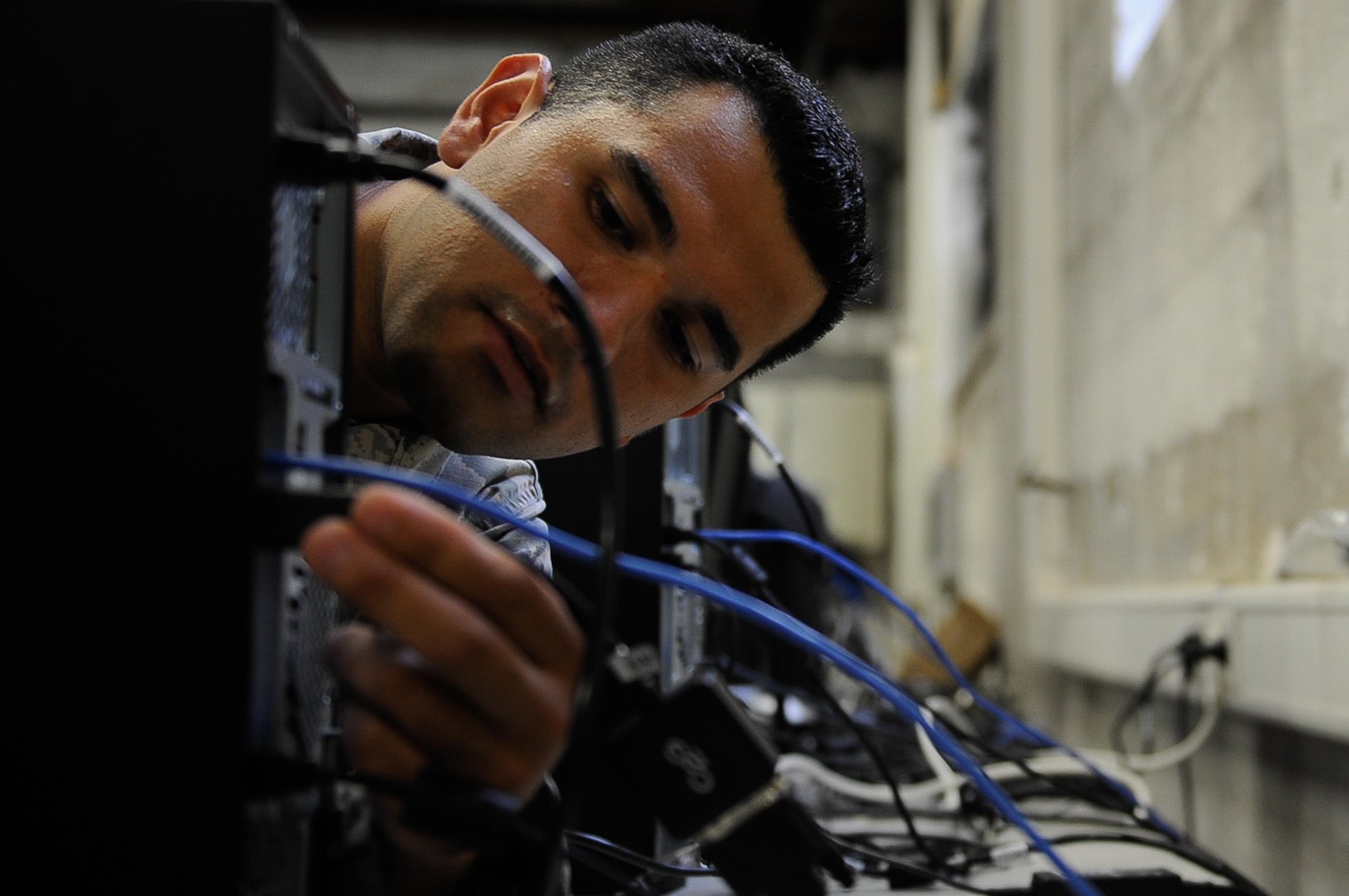 Senior Airman Eric Contreras, 86th Communications Squadron systems acquisitions technician, connects wires to new computers for imaging on Ramstein Air Base, Germany, Aug. 3, 2017. The National Security Agency has directed all of the Department of Defense to make the transition to Microsoft Windows 10. The NSA directive puts all branches of the military on the same operating system for the first time ever. (U.S. Air Force photo by Airman 1st Class Savannah L. Waters)