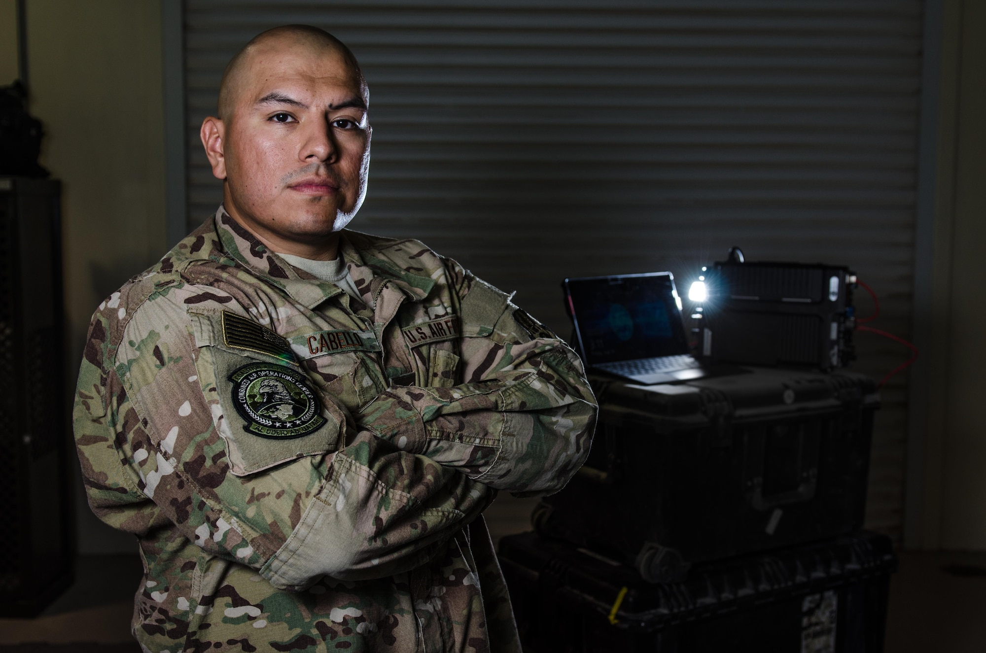 U.S. Air Force Tech. Sgt. Albert Cabello,the 609th Expeditionary Air and Space Communications Squadron NCO in charge of executive communications at the Combined Air Operations Center, stands in front of the new executive  communications kit Aug. 1, 2017, at Al Udeid Air Base, Qatar. The kit provides secure command and control network communications for key Air Force leaders via commercial medians and to offers voice, video, e-mail, and data services anywhere in the world. (U.S. Air Force photo by Staff Sgt. Alexander W. Riedel)