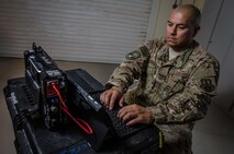 U.S. Air Force Tech. Sgt. Albert Cabello,the 609th Expeditionary Air and Space Communications Squadron NCO in charge of executive communications at the Combined Air Operations Center, tests the new executive  communications kit Aug. 1, 2017, at Al Udeid Air Base, Qatar. Cabello uses the kit to provide secure command and control network communications for key Air Force leaders via commercial medians and to establish voice, video, e-mail, and data services. (U.S. Air Force photo by Staff Sgt. Alexander W. Riedel)