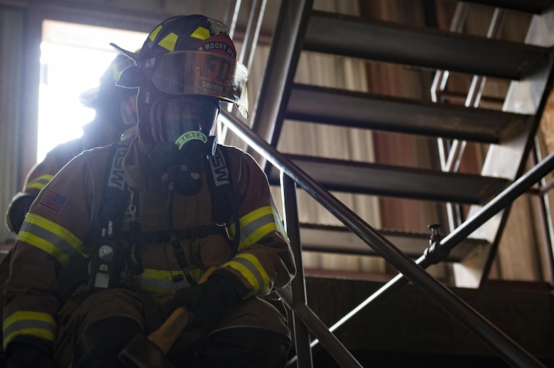 Firefighters from the 23d Civil Engineer Squadron advance down a staircase in a simulated burning building during rapid intervention fire training, Aug. 2, 2017, at Moody Air Force Base, Ga. Rapid intervention refers to the rescue of downed firefighters when they find themselves in trouble. During the course, Moody firefighters, as well as a Lowndes County firefighter, learned how to perform self-rescue, team rescue, and basic skills such as CPR and various carries in order to transport victims. (U.S. Air Force photo by Airman 1st Class Lauren M. Sprunk)