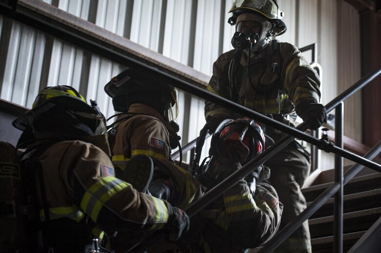 Firefighters from the 23d Civil Engineer Squadron carry a simulated victim up a staircase during rapid intervention fire training, Aug. 2, 2017, at Moody Air Force Base, Ga. Rapid intervention refers to the rescue of downed firefighters when they find themselves in trouble. During the course, Moody firefighters, as well as a Lowndes County firefighter, learned how to perform self-rescue, team rescue, and basic skills such as CPR and various carries in order to transport victims. (U.S. Air Force photo by Airman 1st Class Lauren M. Sprunk)