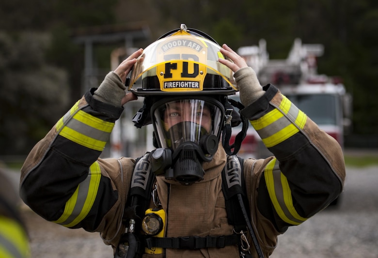 A firefighter from the 23d Civil Engineer Squadron puts his helmet on during rapid intervention fire training, Aug. 3, 2017, at Moody Air Force Base, Ga. Rapid intervention refers to the rescue of downed firefighters when they find themselves in trouble. During the course, Moody firefighters, as well as a Lowndes County firefighter, learned how to perform self-rescue, team rescue, and basic skills such as CPR and various carries in order to transport victims. (U.S. Air Force photo by Airman 1st Class Lauren M. Sprunk)
