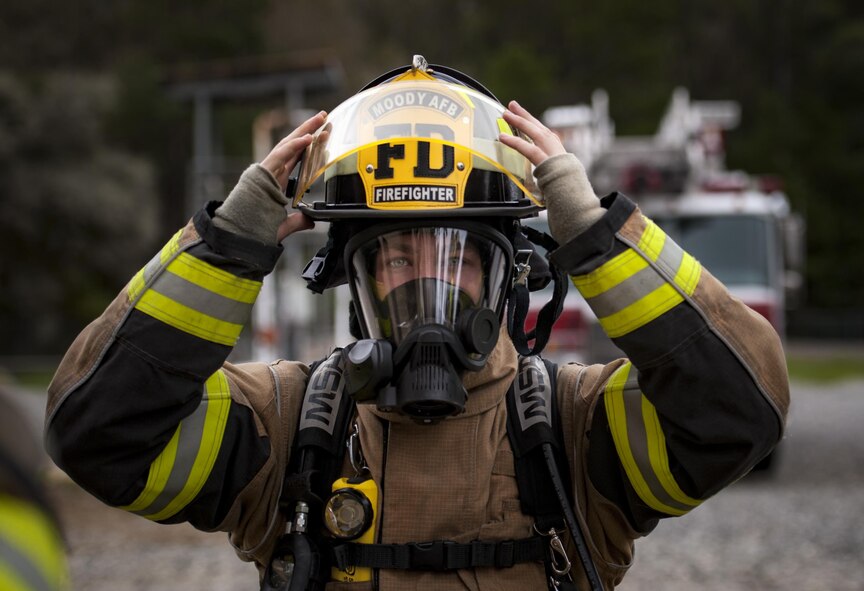 A firefighter from the 23d Civil Engineer Squadron puts his helmet on during rapid intervention fire training, Aug. 3, 2017, at Moody Air Force Base, Ga. Rapid intervention refers to the rescue of downed firefighters when they find themselves in trouble. During the course, Moody firefighters, as well as a Lowndes County firefighter, learned how to perform self-rescue, team rescue, and basic skills such as CPR and various carries in order to transport victims. (U.S. Air Force photo by Airman 1st Class Lauren M. Sprunk)