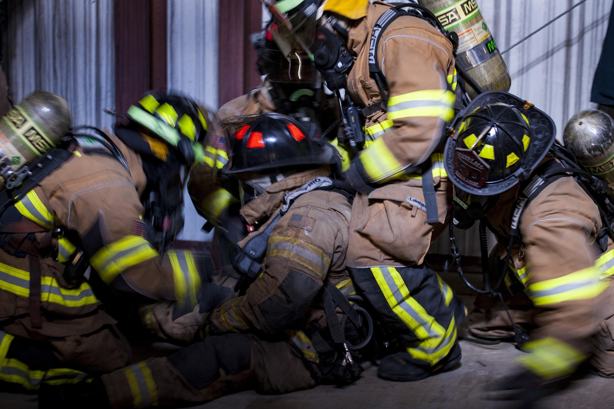 Firefighters from the 23d Civil Engineer Squadron rescue a simulated victim during rapid intervention fire training, Aug. 2, 2017, at Moody Air Force Base, Ga. Rapid intervention refers to the rescue of downed firefighters when they find themselves in trouble. During the course, Moody firefighters, as well as a Lowndes County firefighter, learned how to perform self-rescue, team rescue, and basic skills such as CPR and various carries in order to transport victims. (U.S. Air Force photo by Airman 1st Class Lauren M. Sprunk)