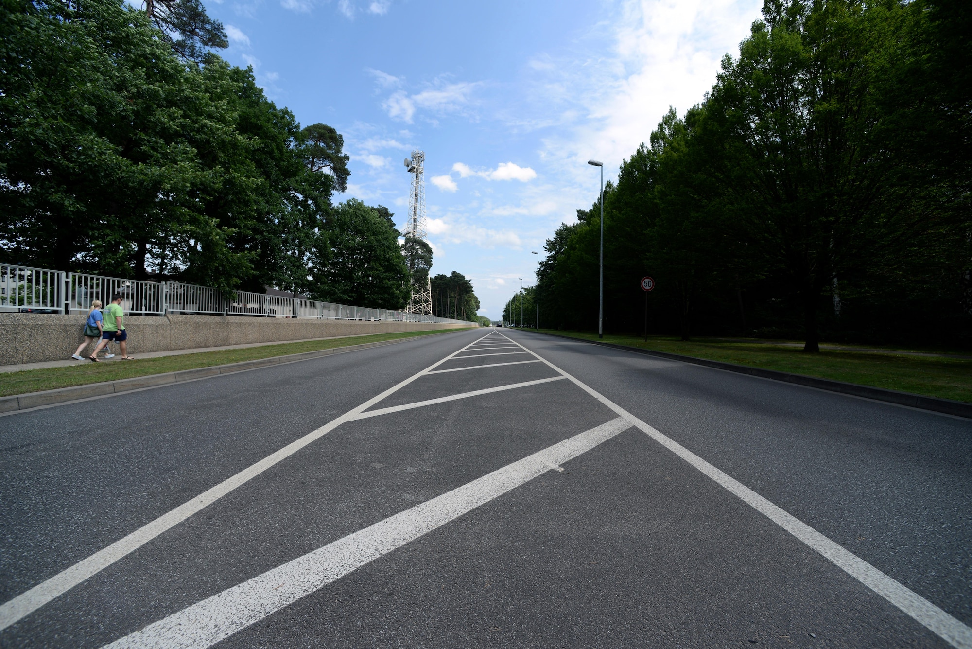 Pedestrians walk down Kisling Memorial Drive on Ramstein Air Base, Germany, Aug. 3, 2017. On Aug. 5, 1952, the airstrip of Landstuhl Air Base, what is now Ramstein Air Base, began air field operations. Landstuhl Air Base’s airstrip is now Kisling Memorial Drive, the main road of Ramstein Air Base that links the east and west gates. (U.S. Air Force photo by Airman 1st Class D. Blake Browning)