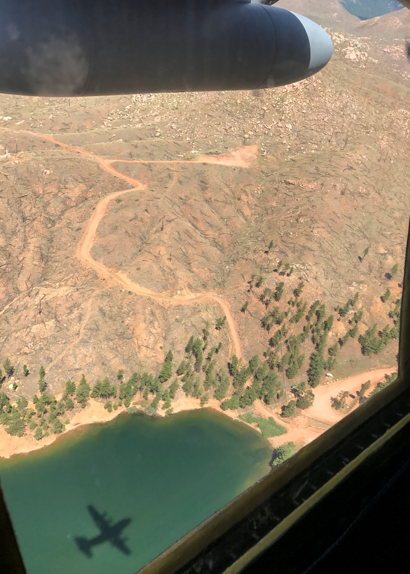 The shadow of a C-130H Hercules is seen over a lake in the Colorado Rockies July 28, 2017. Two Hercules from the 94th Airlift Wing, Dobbins Air Reserve Base, Ga. participated in high-altitude airdrops alongside other Air Force Reserve C-130 wings as part of a training exercise. (Courtesy photo/1st Lt. Will Jones)