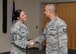 Hanscom Command Chief Master Sgt. Patricia L. Hickey congratulates Tech. Sgt. Raphael M. De La Rosa, noncommissioned officer in charge of Equal Opportunity , during a ceremony at the base conference center in 2016. Hickey will soon transition to be the 375th Air Mobility Wing command chief at Scott Air Force Base in Illinois. (U.S. Air Force photo by Linda LaBonte Britt)