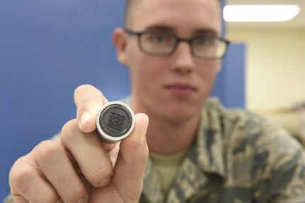 PMEL Airman holds up QC stamp