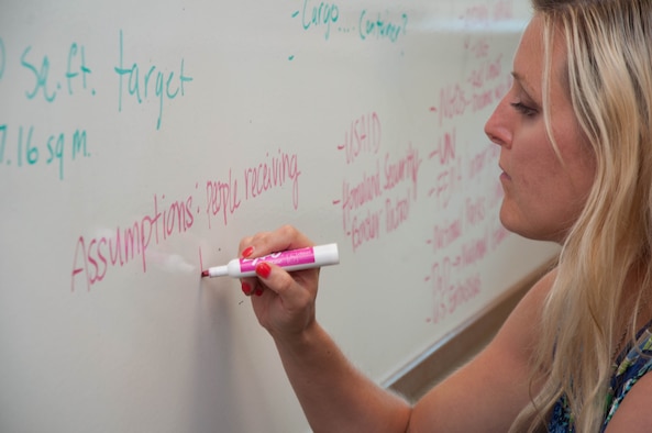 DAYTON, Ohio – Erin Nichols, a program manager on Team Wright-Patt, writes down project assumptions on a team whiteboard during a brainstorming session Aug. 2 as part of the Air Force Research Laboratory’s Commander’s Challenge 2017. The challenge this year is to remotely move 50 pounds of supplies to a location 30 miles away, delivering them to an area smaller than 400 square feet. (U.S. Air Force photo/John Harrington)