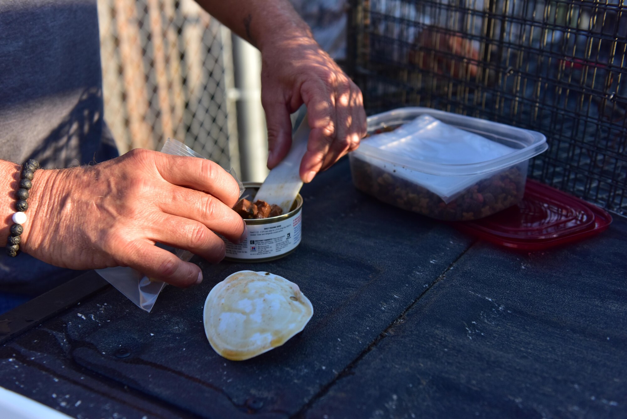 Jim Ivie, a pest control specialist assigned
to the 509th Civil Engineer Squadron,
prepares a bait bag for a pest control
trap at Whiteman Air Force Base, Mo.,
Aug. 2, 2017. Bait bags consist of canned
dog or cat food to help attract animals for
capture.