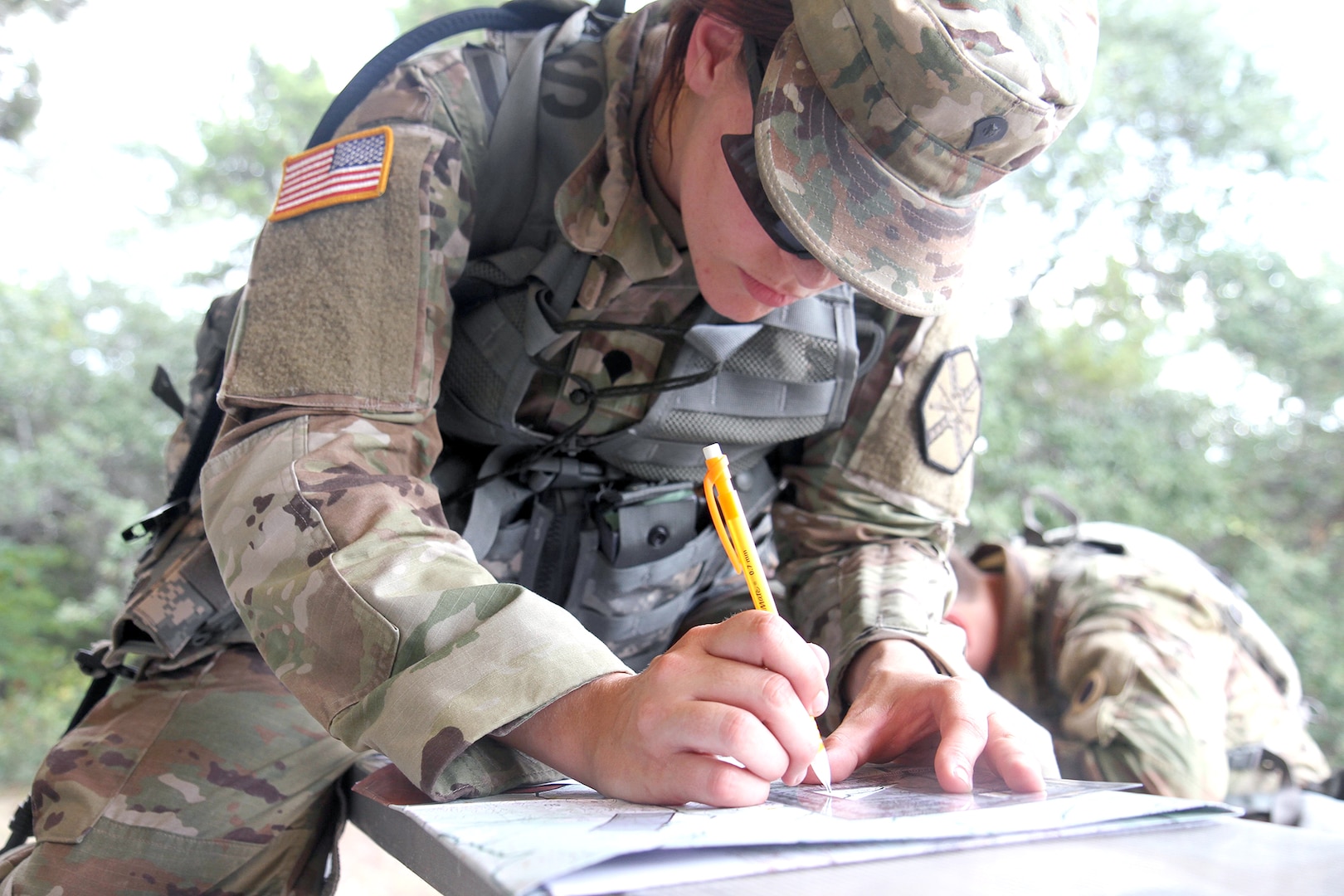 Spc. Lillian Lewis, from Installation Management Command at Fort Riley, Kan., plots her points on a map during the Best Warrior Competition’s day land navigation course June 30 at Joint Base San Antonio-Camp Bullis.