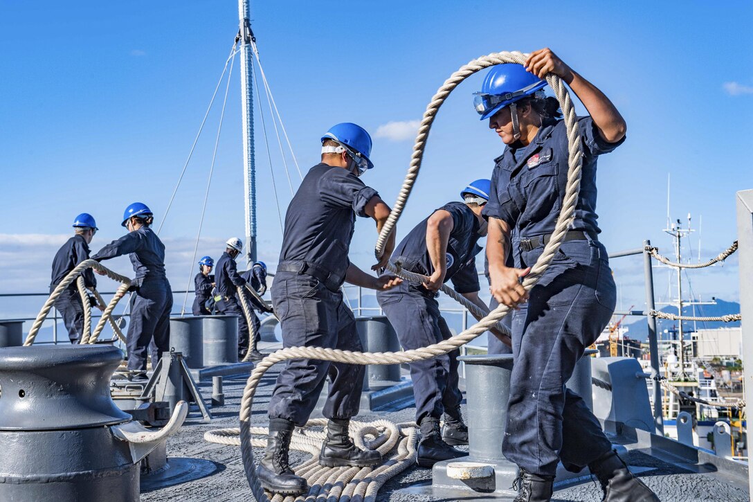 Sailors handle ropes aboard a ship.