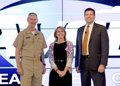 Image: WASHINGTON (July 19, 2017) - Dr. Mary Ann Cummings is flanked by Vice Adm. Thomas Moore, NAVSEA commander, and Jim Smerchansky, NAVSEA executive director at the NAVSEA Excellence Awards and Commander's Awards for Innovation ceremony. She is pictured after receiving the NAVSEA Scientist of the Year Award for a modeling and simulation innovation called Orchestrated Simulation through Modeling (OSM) at the NAVSEA Excellence Awards and Commander's Awards for Innovation ceremony. "We can create simulations that show what could happen and take data from an exercise to show how that exercise might play out as a real event," said Cummings. OSM is now available to the Department of Defense for its programs and exercises.  (U.S. Navy photo/Released)