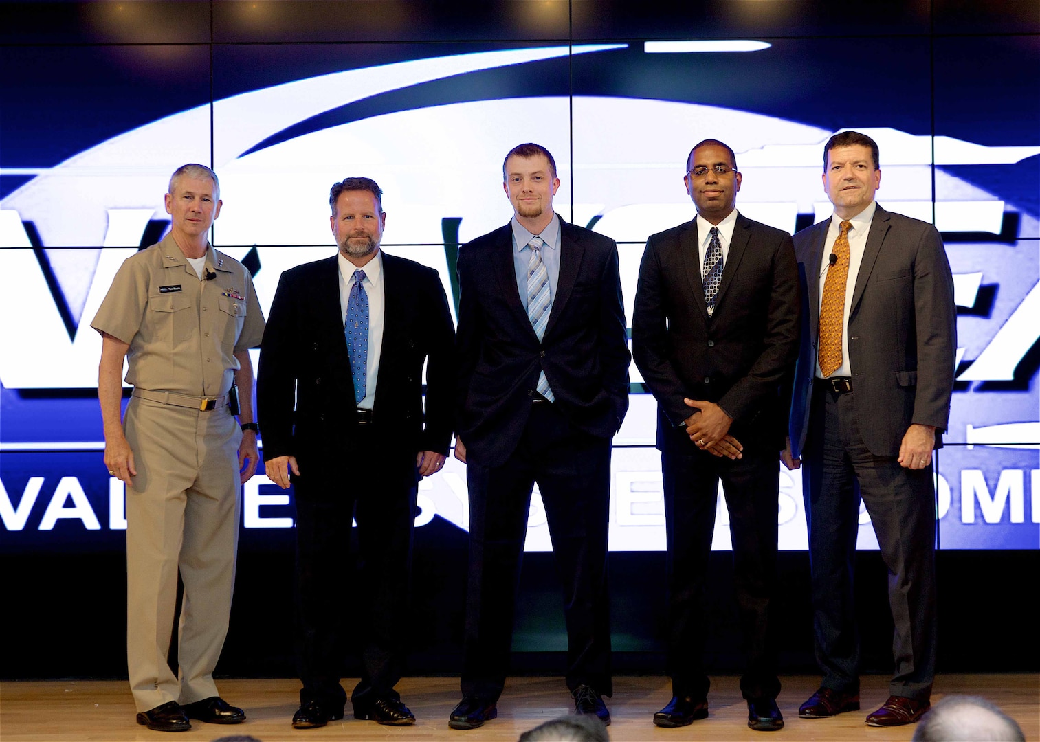 Image: WASHINGTON (July 19, 2017) - Navy engineers Jim Fetsko, Dr. David Hubble, and Mike Weisman (l to r) are flanked by Vice Adm. Thomas Moore, NAVSEA commander, and Jim Smerchansky, NAVSEA executive director at the NAVSEA Excellence Awards and Commander's Awards for Innovation ceremony. They are pictured after receiving the NAVSEA Team Excellence Award on behalf of their   
eight member all-Dahlgren NSWCDD 57mm Pressurized Air Catch System (PACS) Development and Test Team. The team designed, developed, manufactured and successfully tested 57mm PACS in a 16 month timeframe.  "The project was conceived and executed completely in-house," said Fetsko. "The product of this work is a test capability which will allow gun projectile developers the ability to subject their guided projectile hardware to the 57mm tactical gun-launch environment and recover their fired projectile for hands-on survivability and functional assessment."