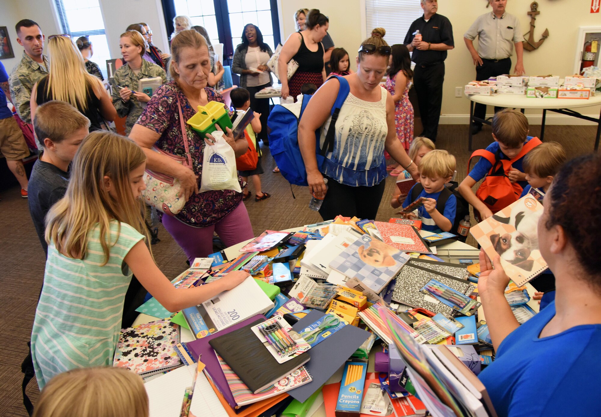 Military families gather assorted school supplies in the Bay Ridge Community Center for a back-to-school event sponsored by Operation Homefront Aug. 1, 2017, on Keesler Air Force Base, Miss. More than 4,000 items and 300 backpacks were donated to 120 military families. (U.S. Air Force photo by Kemberly Groue)