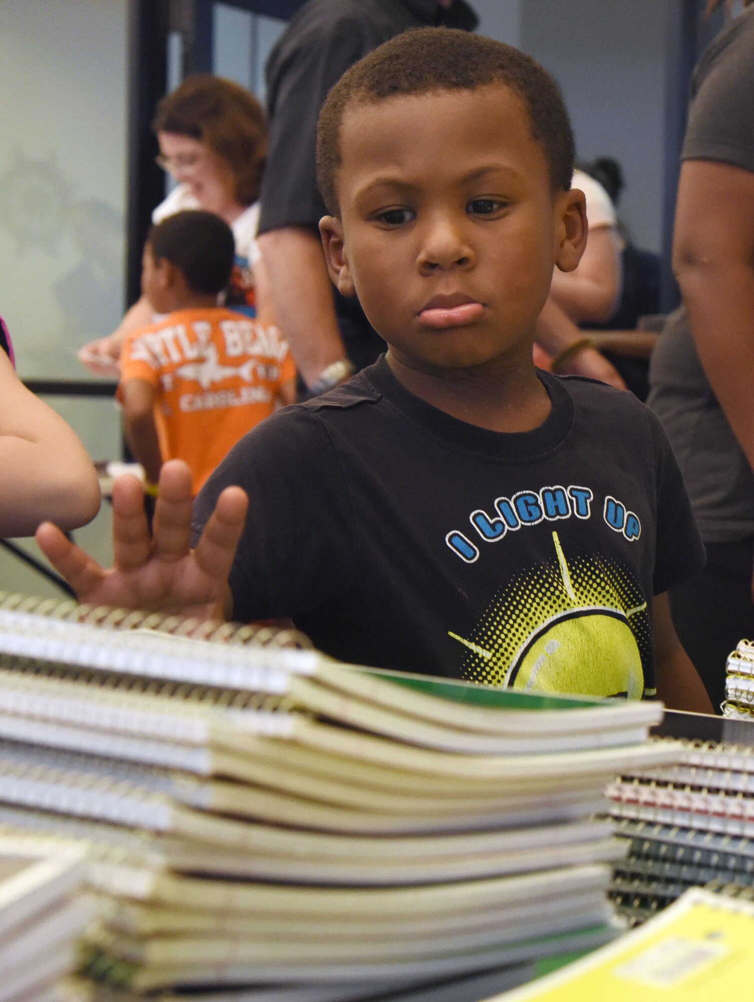 James White, son of Tech. Sgt. Charles White, Jr., 335th Training Squadron military training leader, reaches for a notebook during a back-to-school event sponsored by Operation Homefront in the Bay Ridge Community Center Aug. 1, 2017, on Keesler Air Force Base, Miss. More than 4,000 items and 300 backpacks were donated to 120 military families. (U.S. Air Force photo by Kemberly Groue)