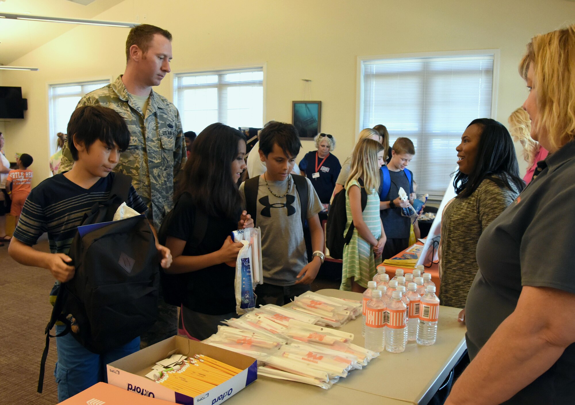 Military families gather assorted school supplies in the Bay Ridge Community Center for a back-to-school event sponsored by Operation Homefront Aug. 1, 2017, on Keesler Air Force Base, Miss. More than 4,000 items and 300 backpacks were donated to 120 military families. (U.S. Air Force photo by Kemberly Groue)