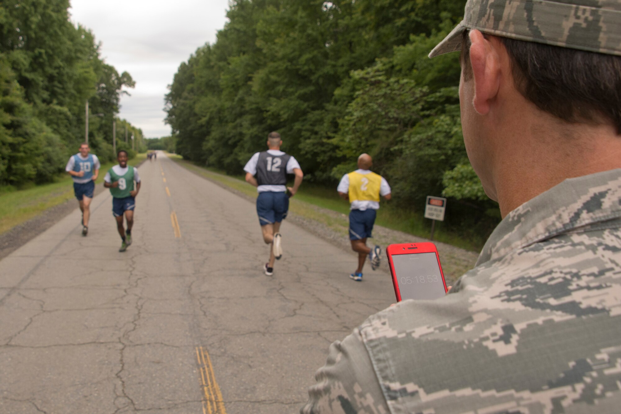 U.S. Air Force Reserve Tech Sgt. Andy Paladino, special handling craftsman, 96th Aerial Port Support Squadron, calls out times at the turnaround point of the 1.5-mile timed run during a physical fitness assessment test at Little Rock Air Force Base, Ark., Aug. 5, 2016. Many Airmen push themselves to score 90 or above, which allows them to test annually, rather than biannually. (U.S. Air Force photo by Master Sgt. Jeff Walston/Released)