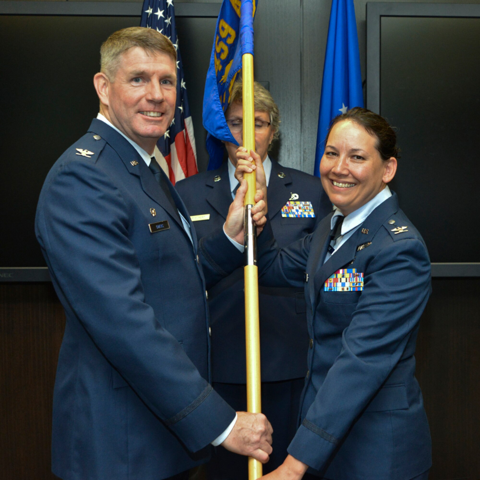 Col. David Owens, commander, 459th Air Refueling Wing, passes the squadron guidon to Col. Kimberly McCue, new commander, 459th Aeromedical Staging Squadron, Joint Base Andrews, Maryland on August  5, 2017. McCue will be responsible for the training and readiness of 140 medical personnel who ensure patients are medically and administratively prepared for flight. (U.S. Air Force photo/Tech. Sgt. Erica J. Knight)